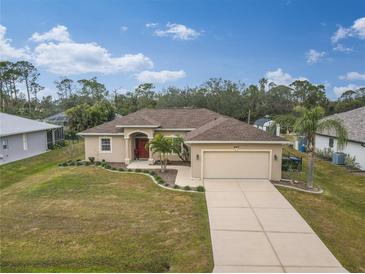 Tan one-story house with a red door and landscaped yard at 4557 Sabrina Ter, North Port, FL 34286