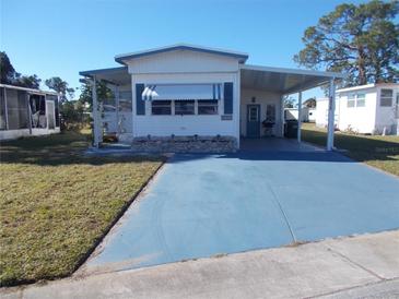 Single-wide mobile home with carport and landscaped lawn at 6815 Amoko Ct, North Port, FL 34287