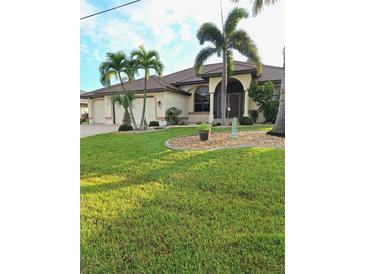 Single-story home with tile roof, palm trees, and a well-manicured lawn at 699 Monaco Dr, Punta Gorda, FL 33950