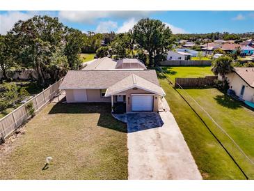 Aerial view of a single-story house with a large backyard and driveway at 701 Coral Way, Englewood, FL 34223