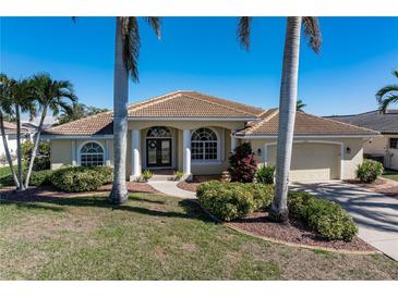 Single-story home with tile roof, two-car garage, and landscaped yard at 1131 Via Tripoli, Punta Gorda, FL 33950