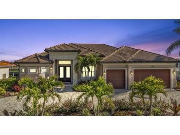 Luxury home with tile roof, two-car garage, and landscaped entry at 1220 Spanish Cay Ln, Punta Gorda, FL 33950