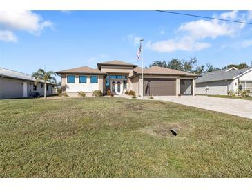 Single-story home with a two-car garage and landscaped lawn at 143 Uruguay Dr, Punta Gorda, FL 33983