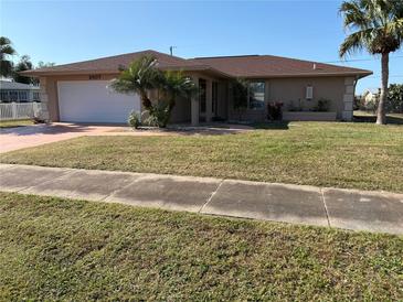 Tan one-story house with a brown tile roof, white garage door, and palm trees at 2507 Lake View Blvd, Port Charlotte, FL 33948