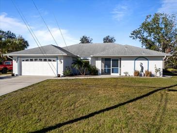 Single-story home with attached garage and landscaped lawn at 11346 Laffite Pl, Port Charlotte, FL 33981