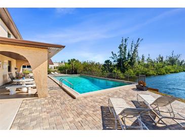 Inviting pool area with patio furniture, overlooking a tranquil canal at 1217 Aqui Esta Dr # 5, Punta Gorda, FL 33950