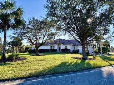 Single-story home with landscaped lawn and driveway at 13264 Creekside Ln, Port Charlotte, FL 33953