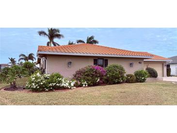 Brick house with lush landscaping, tile roof, and attractive facade at 310 Belvedere Ct, Punta Gorda, FL 33950