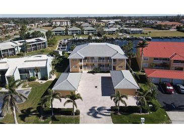 Aerial view of waterfront condo community with boat slips and lush landscaping at 3216 Purple Martin Dr # 123, Punta Gorda, FL 33950