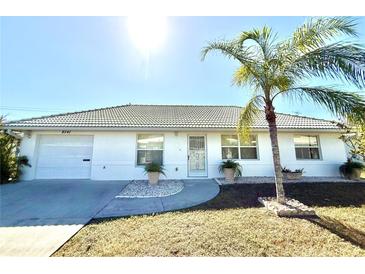 Single-story home with white exterior, attached garage, and palm trees at 8541 Regency Ct, North Port, FL 34287