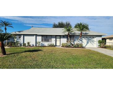 Single-story home with a well-maintained lawn and attached garage at 10454 Waterford Ave, Englewood, FL 34224