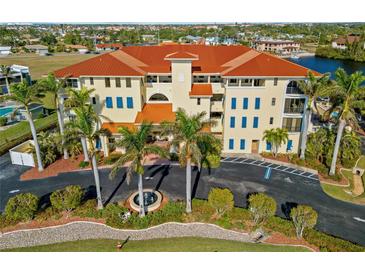 Aerial view of a luxury condo building with palm trees and waterfront access at 1340 Rock Dove Ct # 134, Punta Gorda, FL 33950