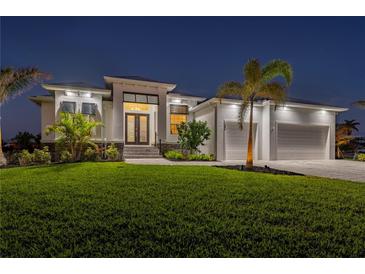 Stunning curb appeal with a modern design, lush lawn, and palm trees at 1380 Willet Ct, Punta Gorda, FL 33950