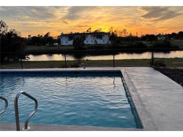 Inviting swimming pool with a sunset view at 143 Rotonda Cir, Rotonda West, FL 33947