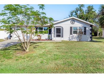 Newly renovated home with a landscaped lawn and driveway at 20430 Dial Ave, Port Charlotte, FL 33952