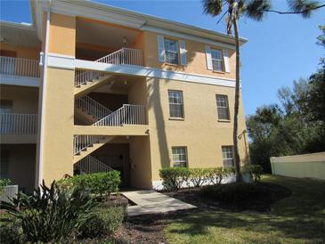 Tan building exterior with stairs and landscaping at 2180 Heron Lake Dr # K-208, Punta Gorda, FL 33983