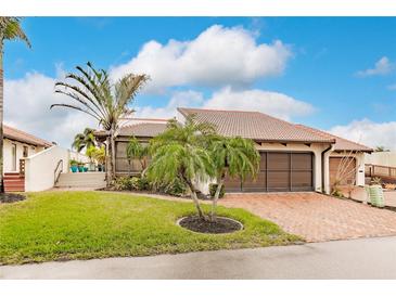 Single-story home with brick driveway, lush landscaping, and a two-car garage at 25188 Marion Ave # 34, Punta Gorda, FL 33950