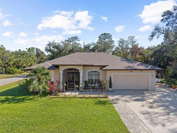 Single-story home with a two-car garage and nicely landscaped lawn at 3008 Yeadon Ter, North Port, FL 34286