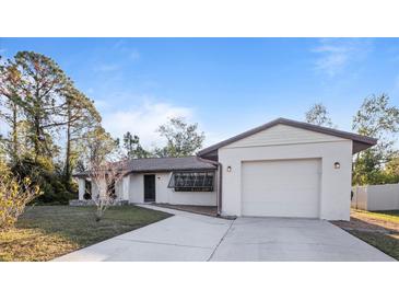 Single-story home with attached garage and landscaped yard at 3128 Ponce De Leon Blvd, North Port, FL 34291