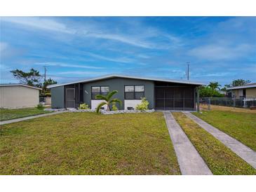 Ranch-style home with gray exterior, landscaping, and double driveway at 350 Duxbury Ave, Port Charlotte, FL 33952