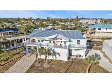 Aerial view of a waterfront home with a metal roof and detached garage at 4297 Nettle Rd, Port Charlotte, FL 33953