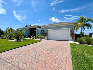 Single-story home with paver driveway, landscaped lawn, and attached garage at 8117 Thruso Rd, Port Charlotte, FL 33981