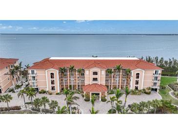 Luxury waterfront condo building with terracotta roof and ample parking at 95 N Marion Ct # 233, Punta Gorda, FL 33950