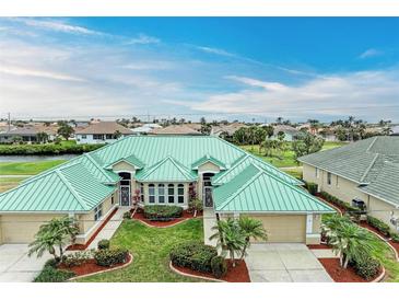 Aerial view of a beautiful home with a green metal roof and lush landscaping at 1551 Atares Dr # 112, Punta Gorda, FL 33950