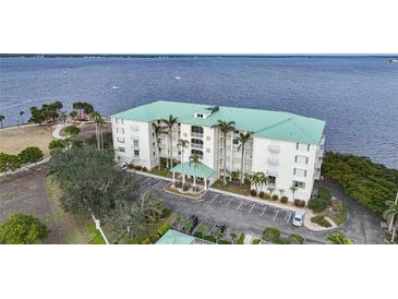 Aerial view of waterfront condo building with parking and water access at 200 Harbor Walk Dr # 144, Punta Gorda, FL 33950