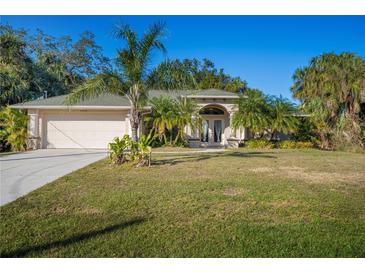 Single-story home with a green roof, attached garage, and palm trees at 3328 Tishman Ave, North Port, FL 34286