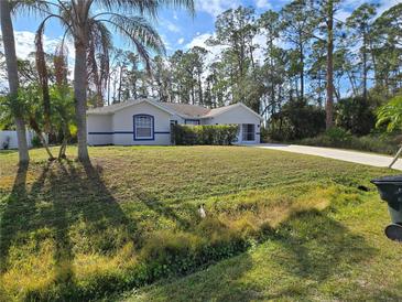 Single-story house with a well-manicured lawn and mature trees at 3739 Eldron Ave, North Port, FL 34286