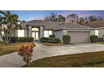 One-story home with attached garage, landscaped yard, and driveway at 5608 New Covington Dr, Sarasota, FL 34233