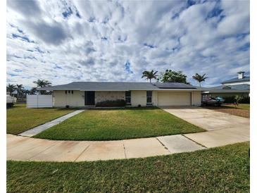 Single-story home with a large yard, attached garage, and solar panels at 258 Beeney Se Rd, Port Charlotte, FL 33952