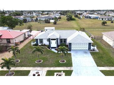 Aerial view of a single-story home with a gray roof and landscaping at 13323 Copper Ave, Port Charlotte, FL 33981