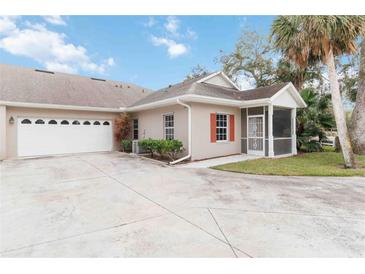 Exterior view of villa with attached garage and screened porch at 1433 Red Oak Ln, Port Charlotte, FL 33948