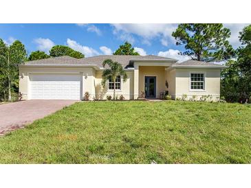 Single-story home with a white garage door and a neatly landscaped lawn at 14386 San Domingo Blvd, Port Charlotte, FL 33981