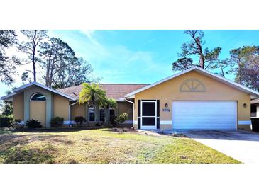 Well-maintained house with a two-car garage and landscaped lawn at 21217 Knollwood Ave, Port Charlotte, FL 33952