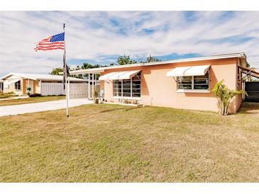 Ranch style home with a well-maintained lawn and American flag at 21354 Austin Ave, Port Charlotte, FL 33952