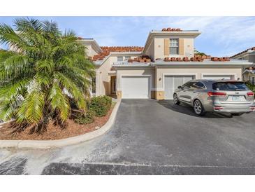 Tan two-story townhome with attached garage and landscaping at 240 W End Dr # 212, Punta Gorda, FL 33950