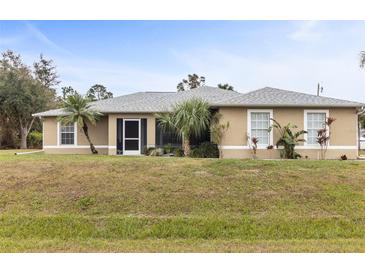 Tan house with gray roof, landscaping, and screened porch at 2411 Altoona Ave, North Port, FL 34286