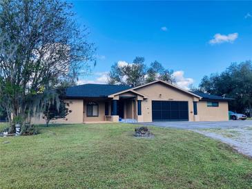 Single-story home with a large yard and attached garage at 27300 San Carlos Dr, Punta Gorda, FL 33983