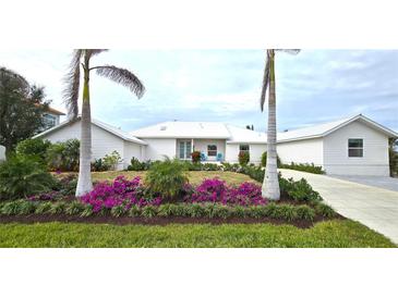 White house with landscaping and palm trees at 311 Bayridge Pl, Punta Gorda, FL 33950