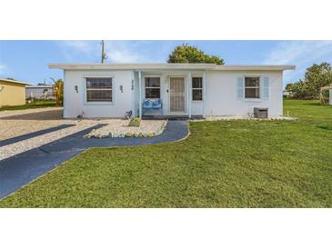 Cute cottage with light blue accents and a well-manicured lawn at 3740 Easy St, Port Charlotte, FL 33952