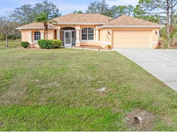 Single-story home with a large front yard and attached garage at 5465 Trumpet St, North Port, FL 34291