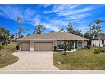 Single-story home with a large driveway, two-car garage, and landscaped yard at 594 Rotonda Cir, Rotonda West, FL 33947