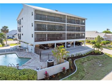 Three-story building with pool and parking, offering waterfront views at 1801 Jamaica Way # 112, Punta Gorda, FL 33950