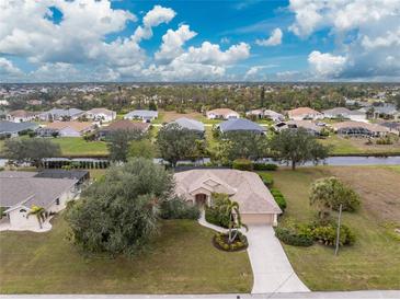 Aerial view of single-Gathering home with canal and neighborhood in background at 188 Broadmoor Ln, Rotonda West, FL 33947