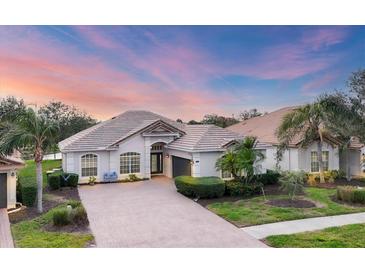 Beautiful one-story home featuring tile roof, manicured landscaping, and brick-paved driveway at 25187 Keygrass Ct, Punta Gorda, FL 33955