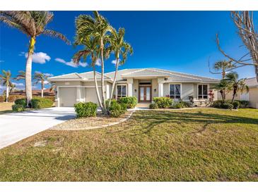 Single-story home with attached garage and lush landscaping at 3932 Madrid Ct, Punta Gorda, FL 33950