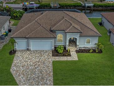 Single-story home with tile roof, three-car garage, and landscaped yard at 4218 Vasco St, Punta Gorda, FL 33950